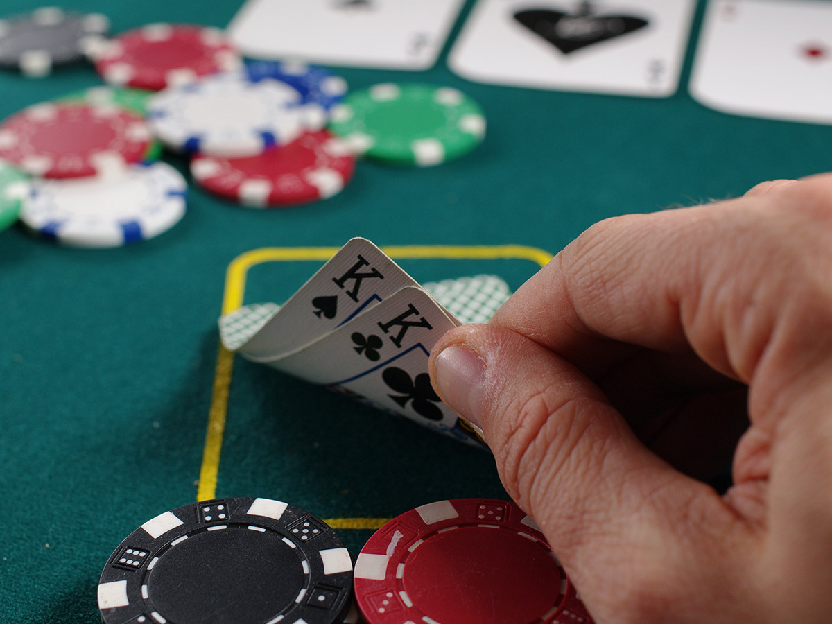 image of a person looking at their cards with poker chips
